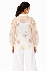 Lightweight ivory sheer finish with scattered pastel florals, a structured collar, and a softly rounded relaxed silhouette.
