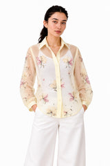 Elegant sheer ivory shirt with a delicate pastel floral print, contrasting cream collar and cuffs, and a classic button-down silhouette.