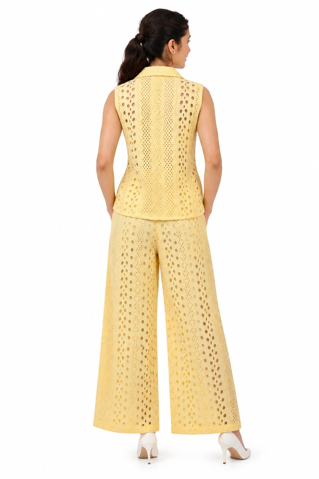 Clean structured back with all-over circular cutwork detailing, complemented by the flowing wide-leg trousers.