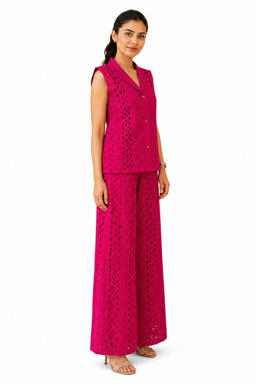 Relaxed tailored silhouette with a defined waist, textured cutwork fabric, and fluid wide-leg trousers creating an effortless profile.