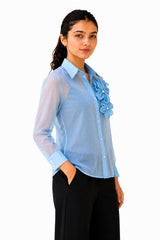 Lightweight sheer silhouette with voluminous sleeves, structured cuffs, and delicate floral detailing adding dimension.