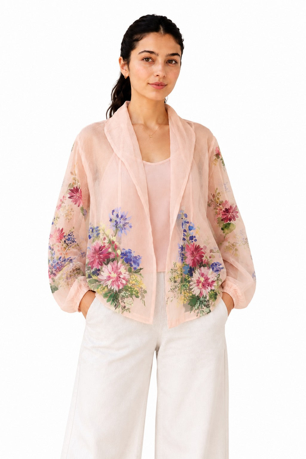 Delicate blush-pink sheer shirt with a soft draped collar and vibrant floral detailing concentrated along the sleeves and lower front.