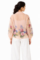 Airy blush-pink sheer finish with a softly draped collar and floral detailing extending across the lower back and sleeves.