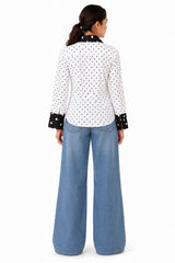 Clean white polka-dot back framed by a contrasting black collar