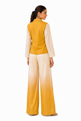Clean mustard-yellow back with a relaxed wrap construction, sheer sleeves, and a polished minimal finish.